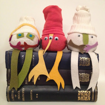 no sew sock dolls sitting ona pile of books